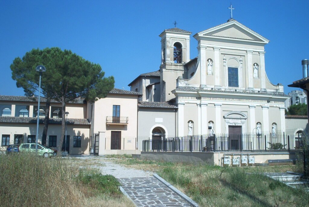 La facciata bianca e il campanile della Basilica di San Valentino a Terni, con un vialetto in primo piano