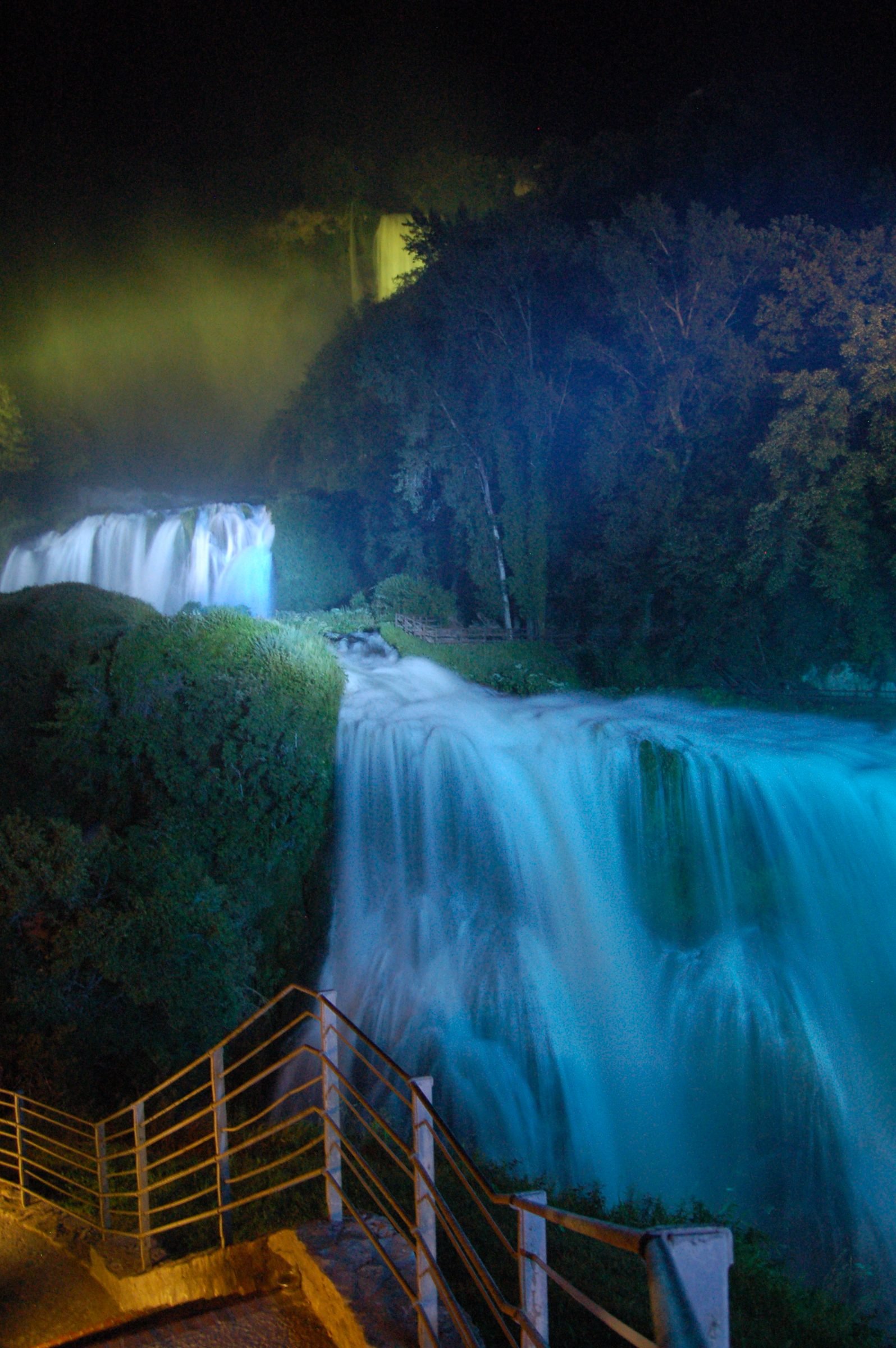 The Marmore Falls floodlit at night, the water lit white against the dark gorge
