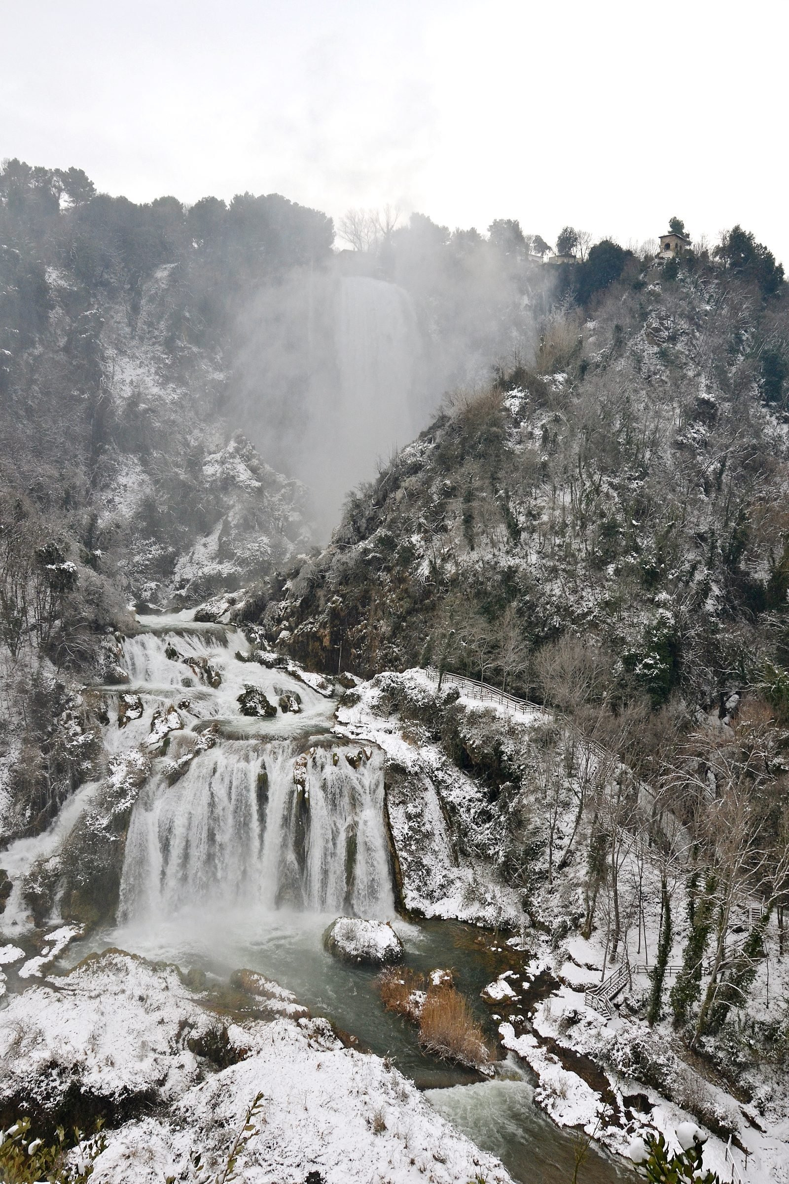 The Marmore Falls under snow, water dropping through a white winter landscape