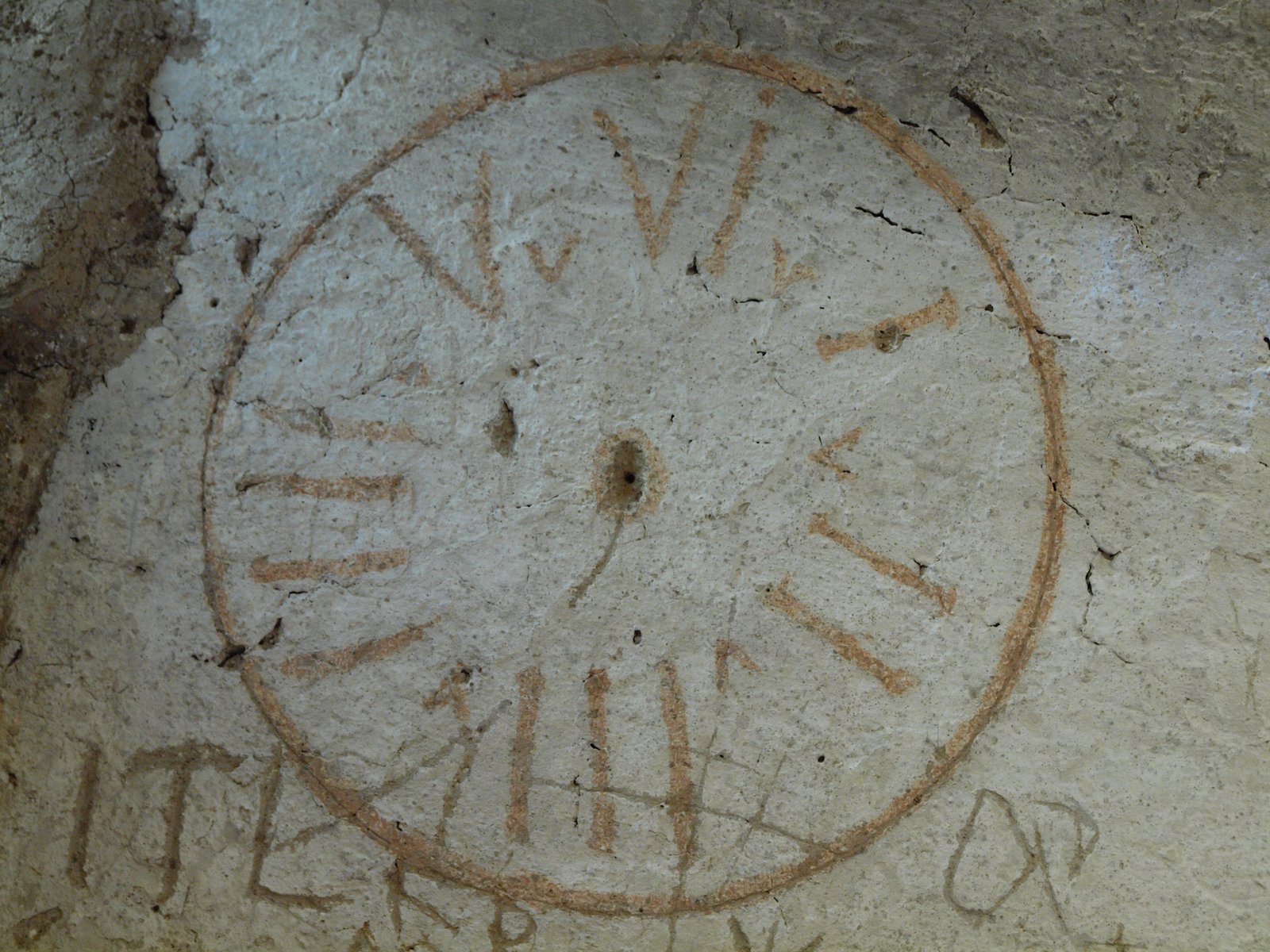 A circular graffito scratched into the plaster of the Inquisition cell at Narni Sotterranea