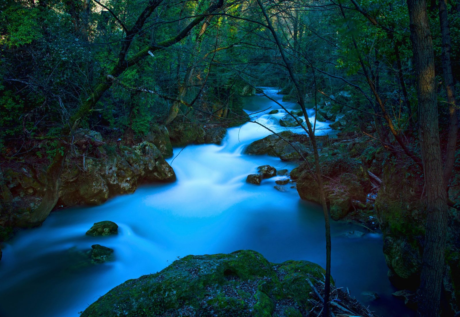 The River Nera flowing between mossy rocks below the Marmore Falls, photographed with a long exposure