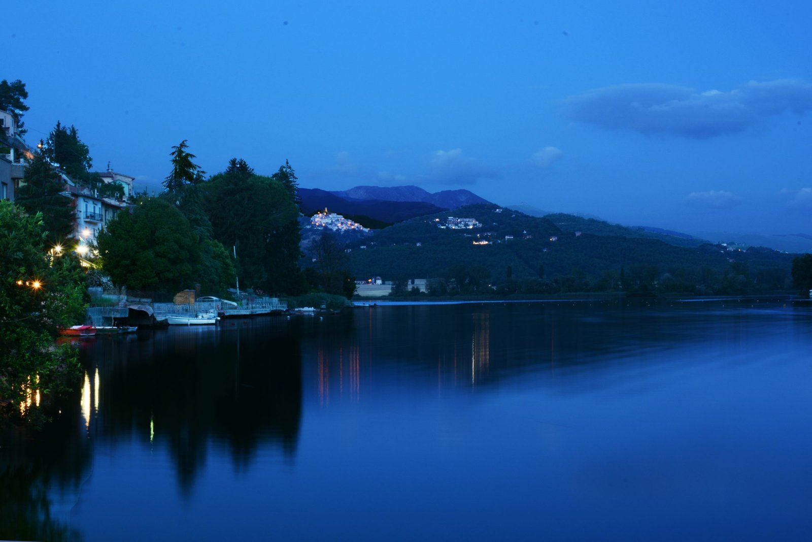 Lake Piediluco at dusk, the village lights reflected across the dark water