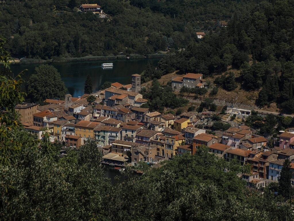 I tetti in cotto e il campanile di Piediluco lungo la riva del lago, visti dalla collina boscosa