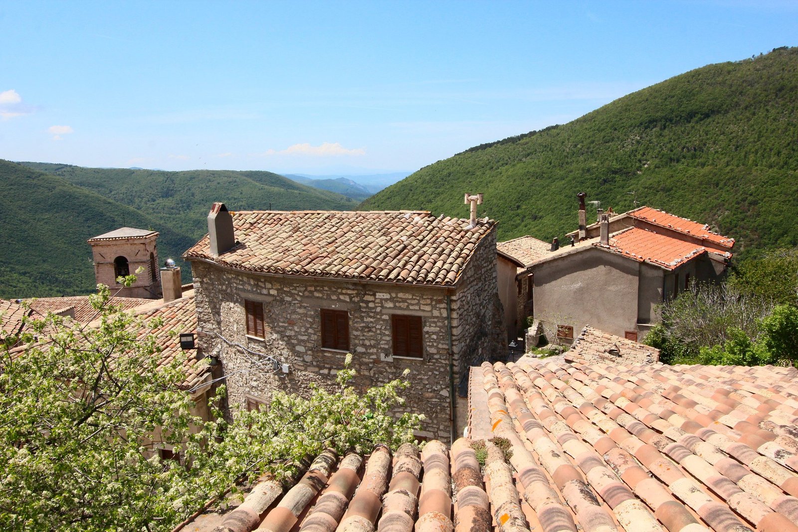 Stone houses and terracotta roofs at Polino, with the Apennine ridges behind