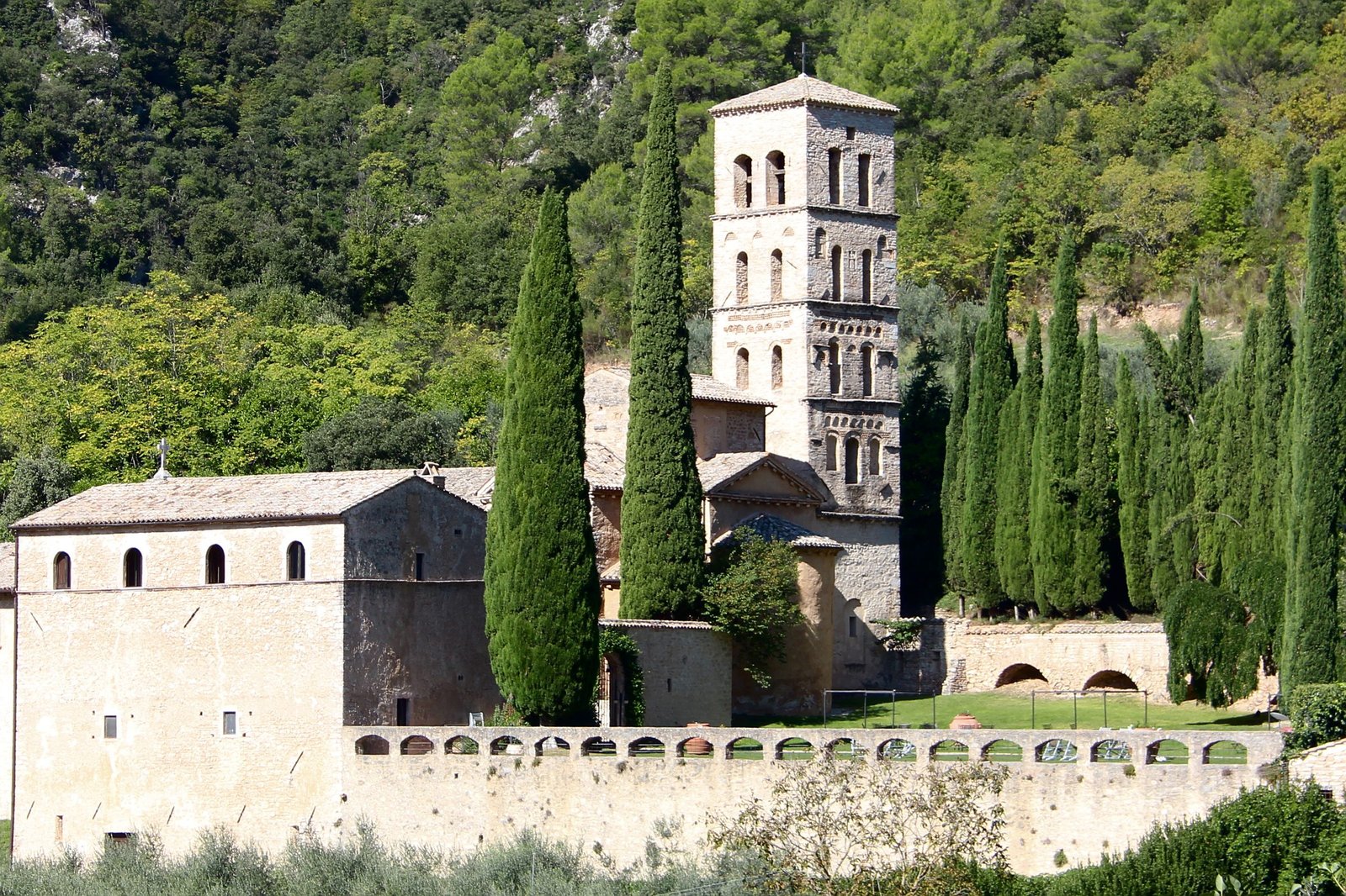 The abbey of San Pietro in Valle with its bell tower and a row of cypresses