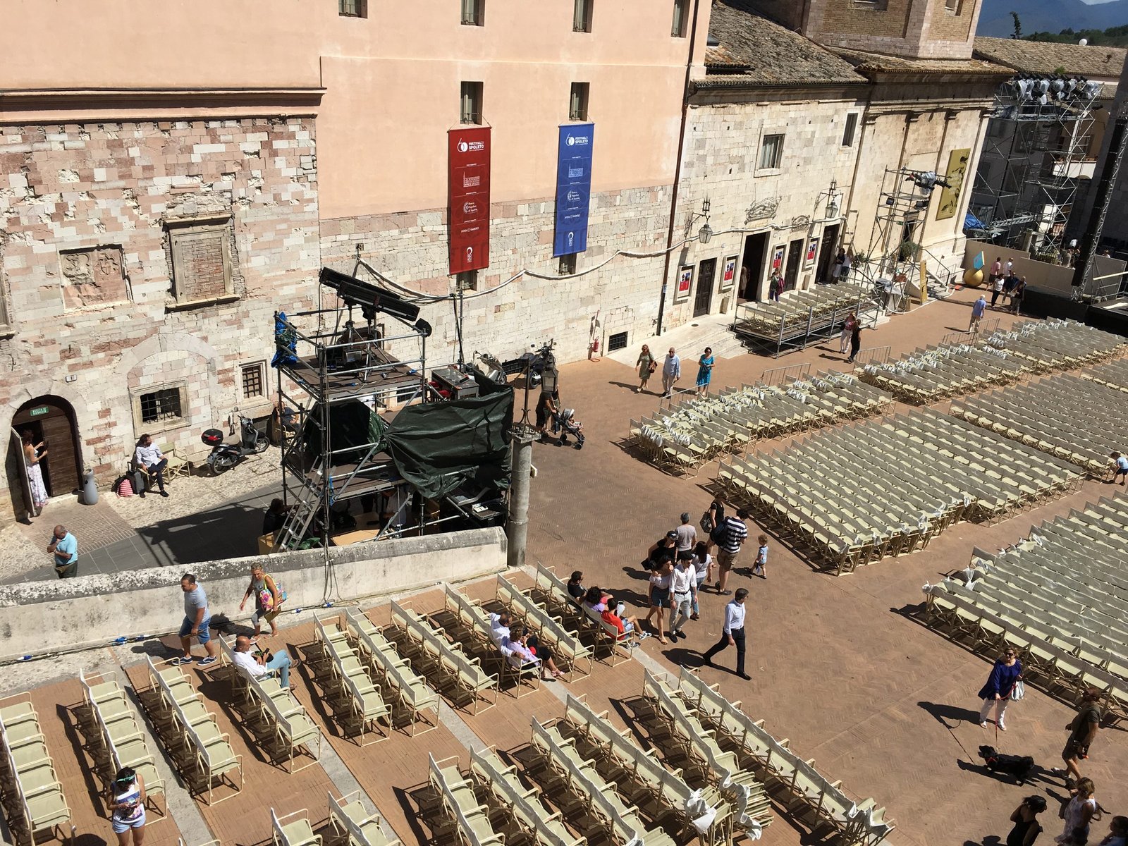 A stage and rows of chairs set up in Piazza del Duomo in Spoleto in front of the cathedral facade