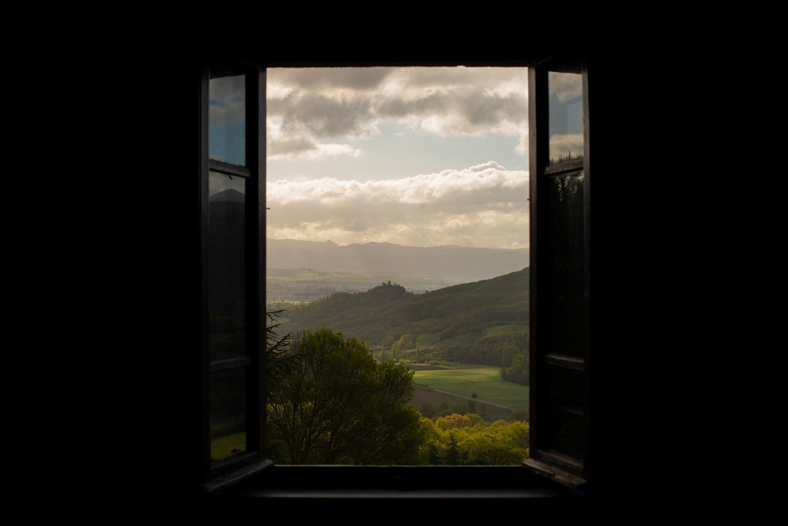 An open window looking out over green Umbrian hills